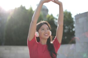 Person enjoying sunlight with smiling face and outstretched arms