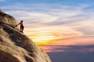 Person climbing a mountain symbolizing overcoming challenges